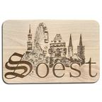 Die Skyline von Soest als Holzgravur auf einem Frühstücksbrettchen, mit großem Schriftzug von Soest